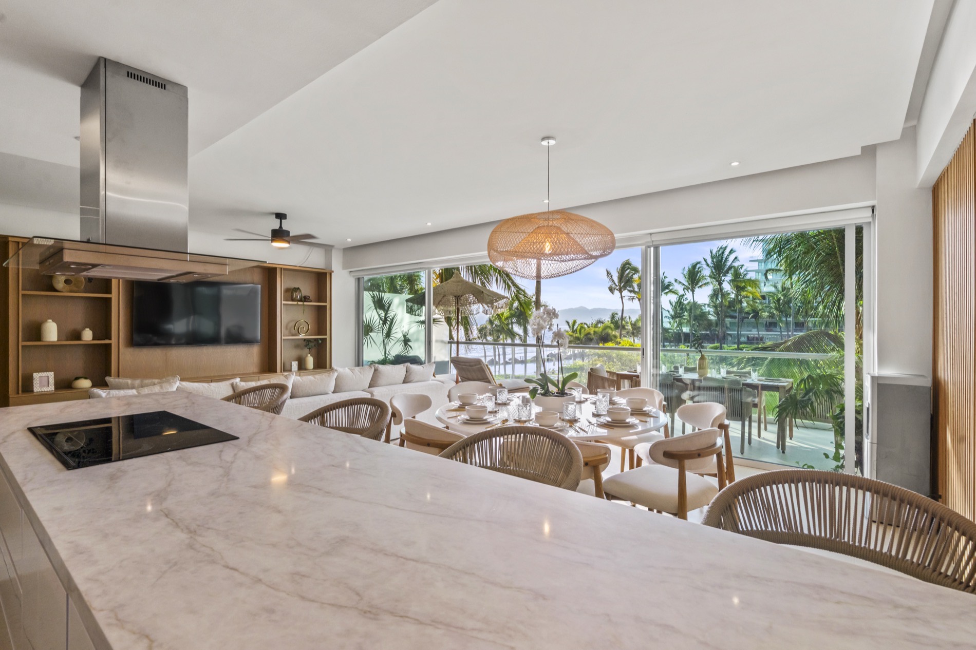 Cocina con isla de mármol abierta al comedor y a la vista del mar